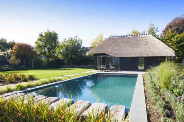 Imposante zwemvijver voorzien van lounge gedeelte en stapstenen in ruwe