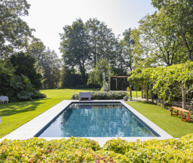 Zwembad in de tuin aangelegd door Azuralux Zwembaden, luxe zwembad