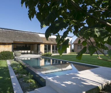 Hybride zwembad met infinityrand bij poolhouse in eikenhout by QPOOLS