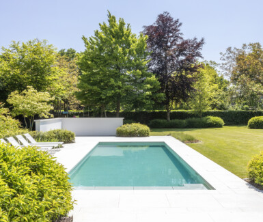 Luxe betonnen zwembad aangelegd in ruime tuin in Jabbeke door Zwembadman, zwembad in de tuin